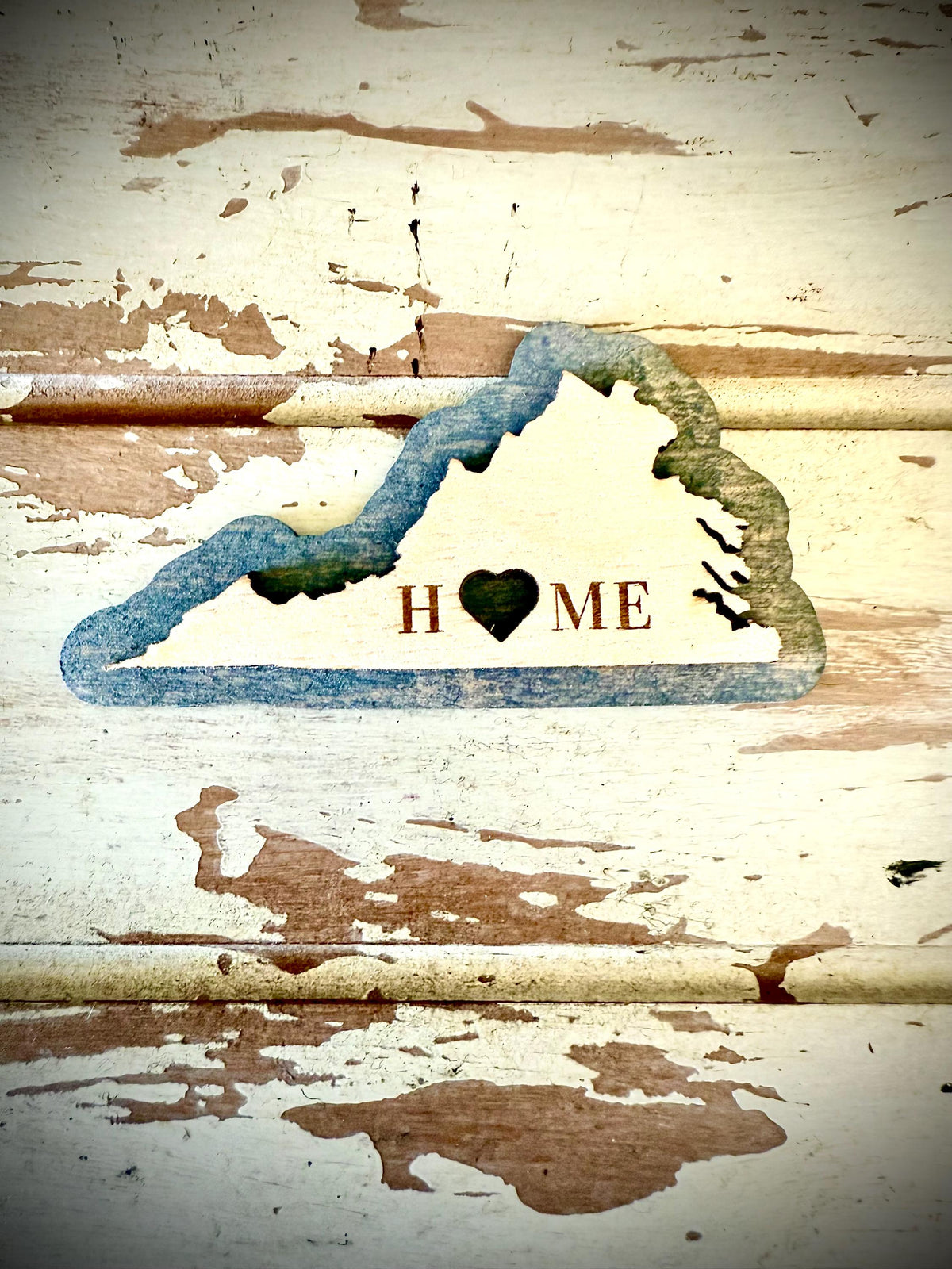 A 2-layer wood refrigerator magnet in the outline of Virginia with the word HOME cut across the state shape.